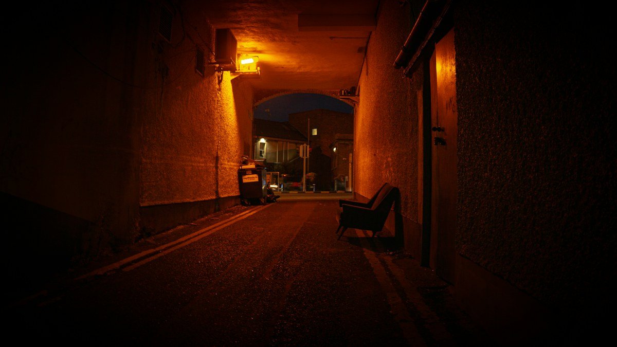 An empty alley in darkness representing horror-film suspense