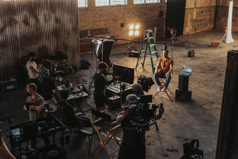 Group of emerging filmmakers collaborating around a cinema camera on a film set